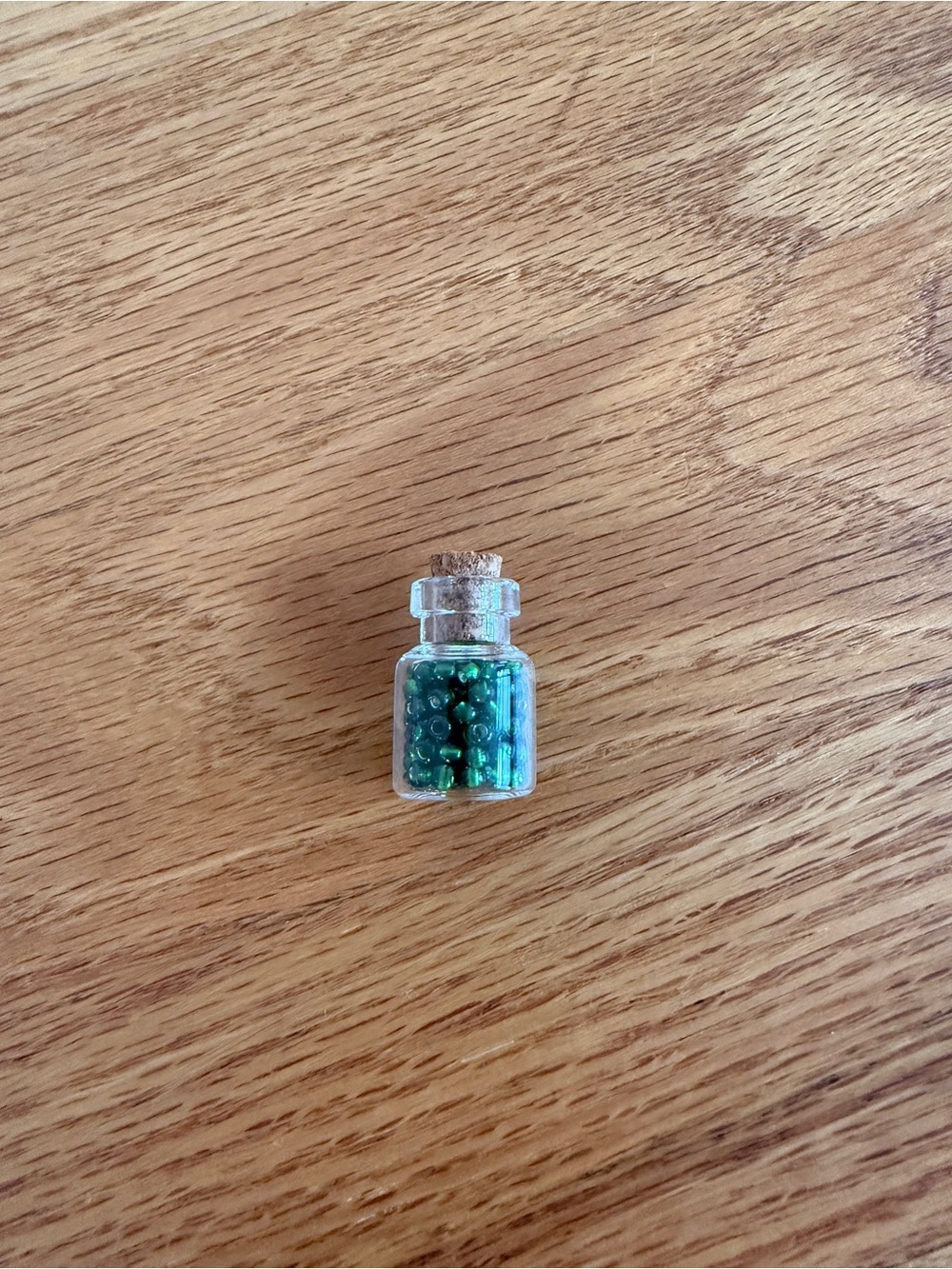 Tiny mini jar of green Czech glass beads